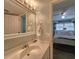 Bright bathroom featuring a sink with a well-lit mirror and a partial view into a bedroom at 18650 Gulf Blvd # 314, Indian Shores, FL 33785