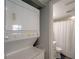 A laundry area with a stacked washer and dryer unit, and view of a bathroom at 18650 Gulf Blvd # 314, Indian Shores, FL 33785