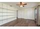 Bedroom with wood floors, built-in shelves, closet, and lots of sunlight at 2165 Campus Dr, Clearwater, FL 33764
