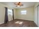 Cozy bedroom with warm wood-look floors, ceiling fan, and natural light from two windows at 2165 Campus Dr, Clearwater, FL 33764