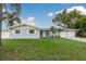 Charming single-story home with blue exterior, lush lawn, and a two-car garage at 2165 Campus Dr, Clearwater, FL 33764