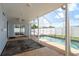 Inviting screened-in pool area with an outdoor rug, adjacent to a covered patio with sliding glass doors at 2165 Campus Dr, Clearwater, FL 33764