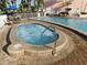Hot tub and community pool surrounded by brick pavers with lounge chairs at 219 Pompano Se Dr # D, St Petersburg, FL 33705