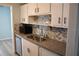 Charming kitchen features tile backsplash, stainless steel appliances, and bright white cabinets at 219 Pompano Se Dr # D, St Petersburg, FL 33705