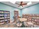 Community library room with floor-to-ceiling bookshelves, ceiling fan, and round table at 219 Pompano Se Dr # D, St Petersburg, FL 33705