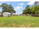 Spacious backyard with lush green grass, a shed, and a privacy fence, perfect for outdoor activities at 2306 Cheryl Rd, Largo, FL 33771