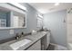Modern bathroom with dual sinks, stone countertops, decorative mirrors, and tiled shower/bath creating luxurious features at 2306 Cheryl Rd, Largo, FL 33771
