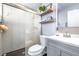 Updated bathroom featuring a glass shower, gray vanity, and floating shelves at 3002 W Cleveland St # B9, Tampa, FL 33609