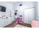 Bright bedroom featuring a modern gray wall color, a tv, wood floors, and a closet at 3002 W Cleveland St # B9, Tampa, FL 33609