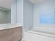 Bright bathroom features a modern vanity, soaking tub, and stylish light blue walls at 301 1St S St # 1601, St Petersburg, FL 33701