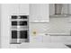 Modern white kitchen with stainless steel appliances and a decorative tile backsplash at 301 1St S St # 1601, St Petersburg, FL 33701