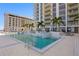 Upscale rooftop pool area with clear blue waters, modern lounge seating, and lush palm trees, offering a resort-style atmosphere at 301 1St S St # 1601, St Petersburg, FL 33701