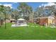 Expansive backyard featuring lush green grass, a unique enclosed above-ground pool, and mature trees at 3106 E Diana St, Tampa, FL 33610