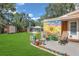 Charming backyard patio area with colorful mural, seating, and lush green lawn at 3106 E Diana St, Tampa, FL 33610