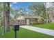 Inviting home with lush green lawn, a paved driveway, and a mailbox, complemented by mature trees at 3106 E Diana St, Tampa, FL 33610