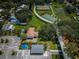 Aerial view of a park with tennis courts, basketball court, and a pedestrian bridge surrounded by lush greenery and community amenities at 3150 San Jose St, Clearwater, FL 33759