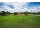 Scenic baseball field with lush green grass and a well-kept clay infield, set under a bright, partly cloudy sky at 3150 San Jose St, Clearwater, FL 33759