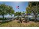 View of a community park with picnic shelters, lush landscaping, and an American flag waving in the distance at 3150 San Jose St, Clearwater, FL 33759