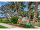 The Del Oro Groves Estates stone entrance sign is surrounded by tropical palms and colorful foliage at 3150 San Jose St, Clearwater, FL 33759