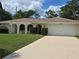Charming single-story home with arched entryway, two-car garage, and well-maintained lawn at 3150 San Jose St, Clearwater, FL 33759