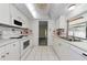 Bright kitchen featuring white cabinets, appliances, and a window above the sink at 3150 San Jose St, Clearwater, FL 33759