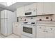Kitchen with white appliances, laminate countertops, and ample storage at 3150 San Jose St, Clearwater, FL 33759