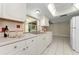 Bright kitchen featuring white cabinets, laminate countertops, and a view to the back patio at 3150 San Jose St, Clearwater, FL 33759