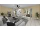 Staged living room with neutral decor, a view of the eat-in kitchen, and a slider to the pool area at 3150 San Jose St, Clearwater, FL 33759