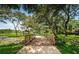 A wooden bridge adds charm to this park, leading through a lush landscape filled with mature trees and green grass at 3150 San Jose St, Clearwater, FL 33759