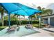 Outdoor picnic area featuring shaded tables under a blue canopy, with lush greenery and a restroom at 3150 San Jose St, Clearwater, FL 33759