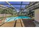 Large screened-in pool with sunny lounging area surrounded by mature trees at 3150 San Jose St, Clearwater, FL 33759