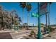 Street view with signs, benches, greenery, and palm trees under a bright blue sky at 3150 San Jose St, Clearwater, FL 33759