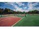 A view of well-maintained tennis courts with vibrant green and red surfaces, promising excellent recreational opportunities at 3150 San Jose St, Clearwater, FL 33759