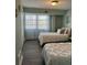 Charming bedroom with twin beds, featuring a light green color scheme, and a window with sheer curtains at 3315 58Th S Ave # 421, St Petersburg, FL 33712