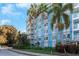 Close exterior shot of a condo building with palm trees and private balconies at 3315 58Th S Ave # 421, St Petersburg, FL 33712