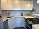 Updated kitchen featuring white cabinets, stone countertops, mosaic backsplash, and stainless steel appliances at 3315 58Th S Ave # 421, St Petersburg, FL 33712