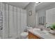 Well-lit bathroom featuring a shower with a patterned curtain, a vanity, and neutral decor at 3455 Castle Stone Ct, Valrico, FL 33594