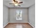 Bedroom with wood-look floors, a ceiling fan, and natural light from the window at 3455 Castle Stone Ct, Valrico, FL 33594