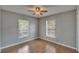 Bedroom featuring wood-look floors, a ceiling fan, and natural light from two windows at 3455 Castle Stone Ct, Valrico, FL 33594