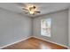 Bedroom with wood-look floors, a ceiling fan, and natural light from the window at 3455 Castle Stone Ct, Valrico, FL 33594