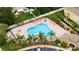 Aerial view of a lovely community pool area with lounge chairs, palm trees, and a secured perimeter fence at 3455 Castle Stone Ct, Valrico, FL 33594