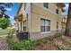 Charming tan condo with well-manicured landscaping and visible unit number, featuring an installed air conditioning unit at 3455 Castle Stone Ct, Valrico, FL 33594