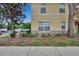 Exterior view of the tan condo with accessible parking sign; manicured landscaping, sidewalk, and installed air conditioning unit at 3455 Castle Stone Ct, Valrico, FL 33594