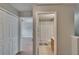 Hallway view of a bathroom with tiled floors and a shower curtain, and bedroom with wood-look floors at 3455 Castle Stone Ct, Valrico, FL 33594