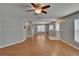 Bright and open living room featuring wood-look floors, modern ceiling fan, neutral paint, and large windows at 3455 Castle Stone Ct, Valrico, FL 33594