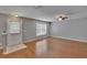 Spacious living area featuring wood-look floors, a modern ceiling fan, a large window, and an exterior door at 3455 Castle Stone Ct, Valrico, FL 33594