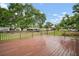 Wide wooden back deck with railing and views of the spacious backyard and blue skies at 37732 Cecil Ln, Zephyrhills, FL 33542