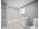 Modern bathroom features a new vanity, toilet, built-in shelving and a tub with white marble backsplash at 37732 Cecil Ln, Zephyrhills, FL 33542