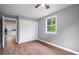 Bright bedroom with hardwood flooring, closet, and an open doorway to other parts of the home at 37732 Cecil Ln, Zephyrhills, FL 33542