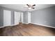 Bedroom with wood floors, ceiling fan, and multiple doors leading to other rooms at 37732 Cecil Ln, Zephyrhills, FL 33542